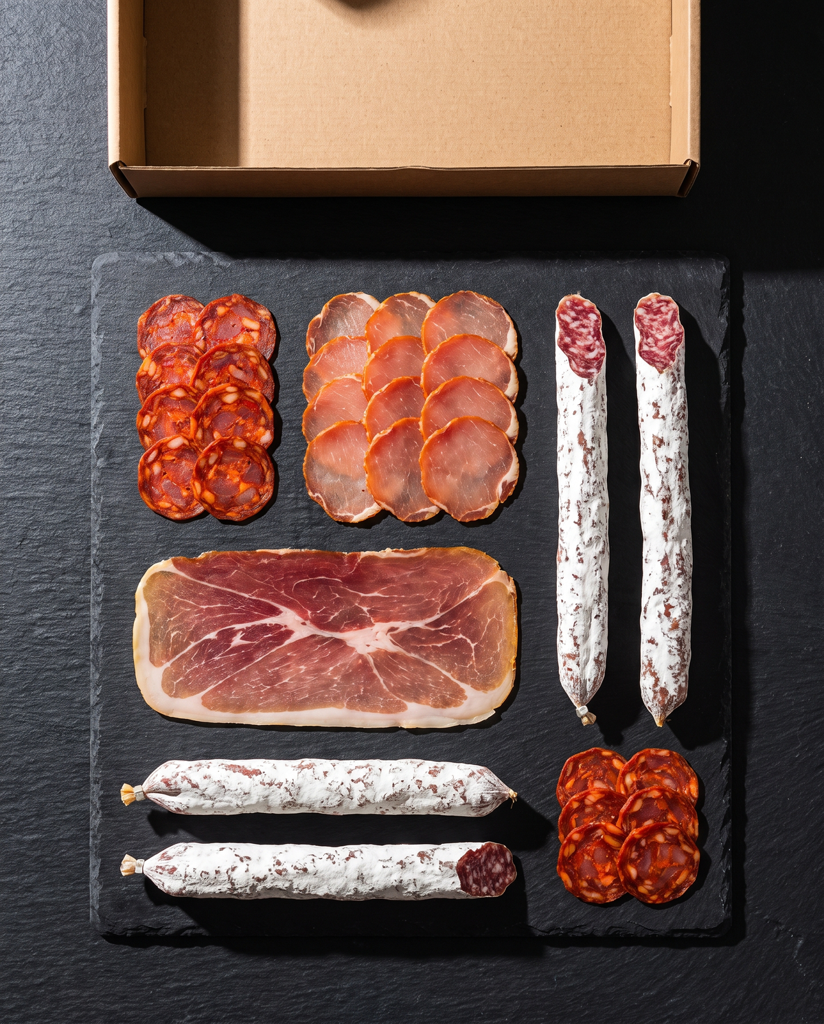 Charcuteries artisanales alignées sur une ardoise pour un apéro